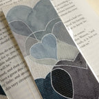 Close-up of grey watercolour hearts bookmark with metallic silver outlines.