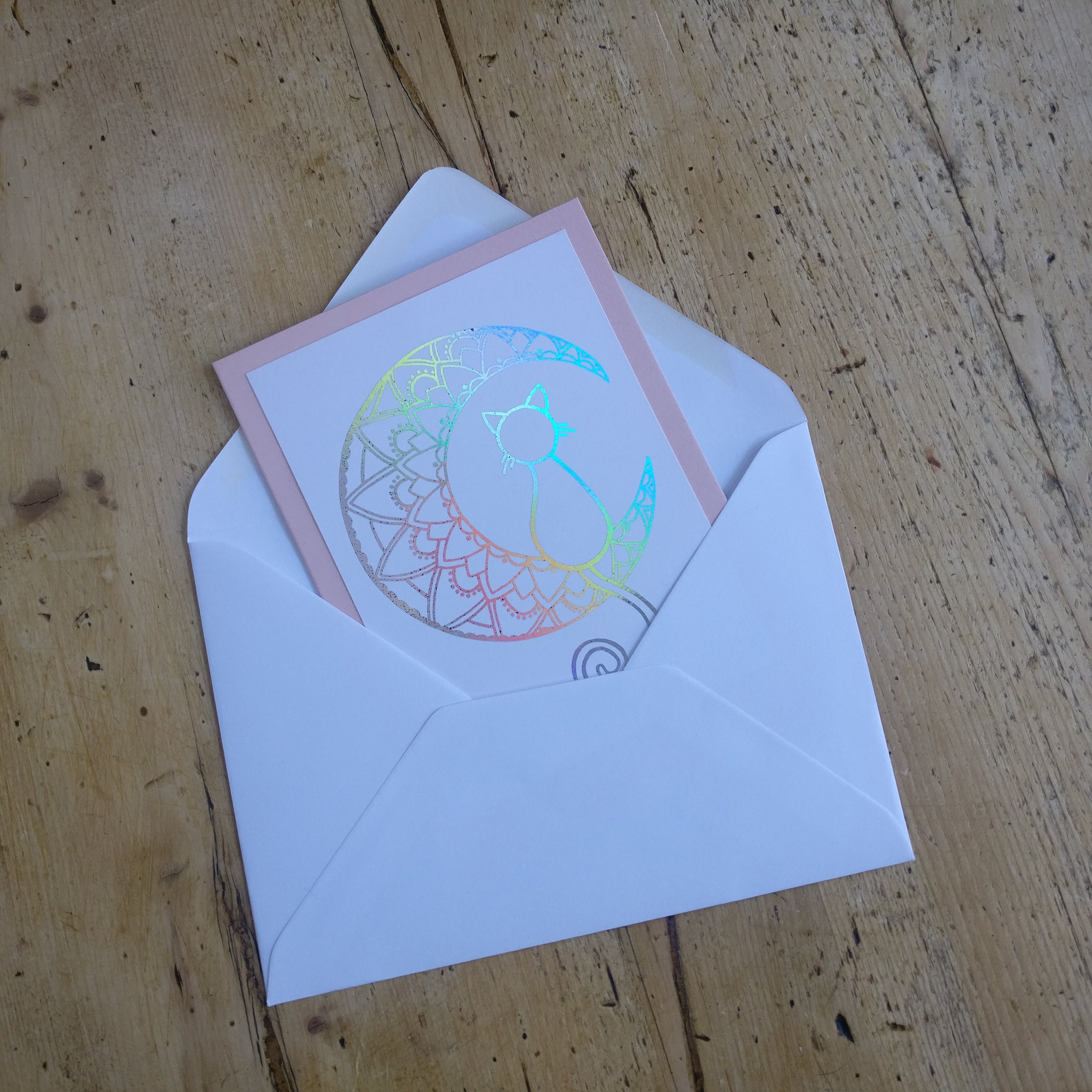 Holographic card with envelope on a wooden surface