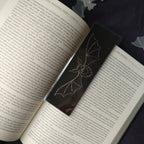 The medium Shadow Bat Bookmark on an open book.