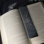 The large Shadow Bat Bookmark on an open book.