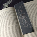 Medium Shadow Bat Bookmark on an open book, closer view showing the soft foil shine.
