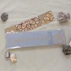 An aqua-coloured Mandala Bookmark with one of the handmade package backings with a hand-written "happy reading" and a mandala corner in gold.