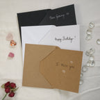 Example photo of the three different card and envelope colours that are available within this shop, with writing samples in black and/or white on the cards' blank insides.