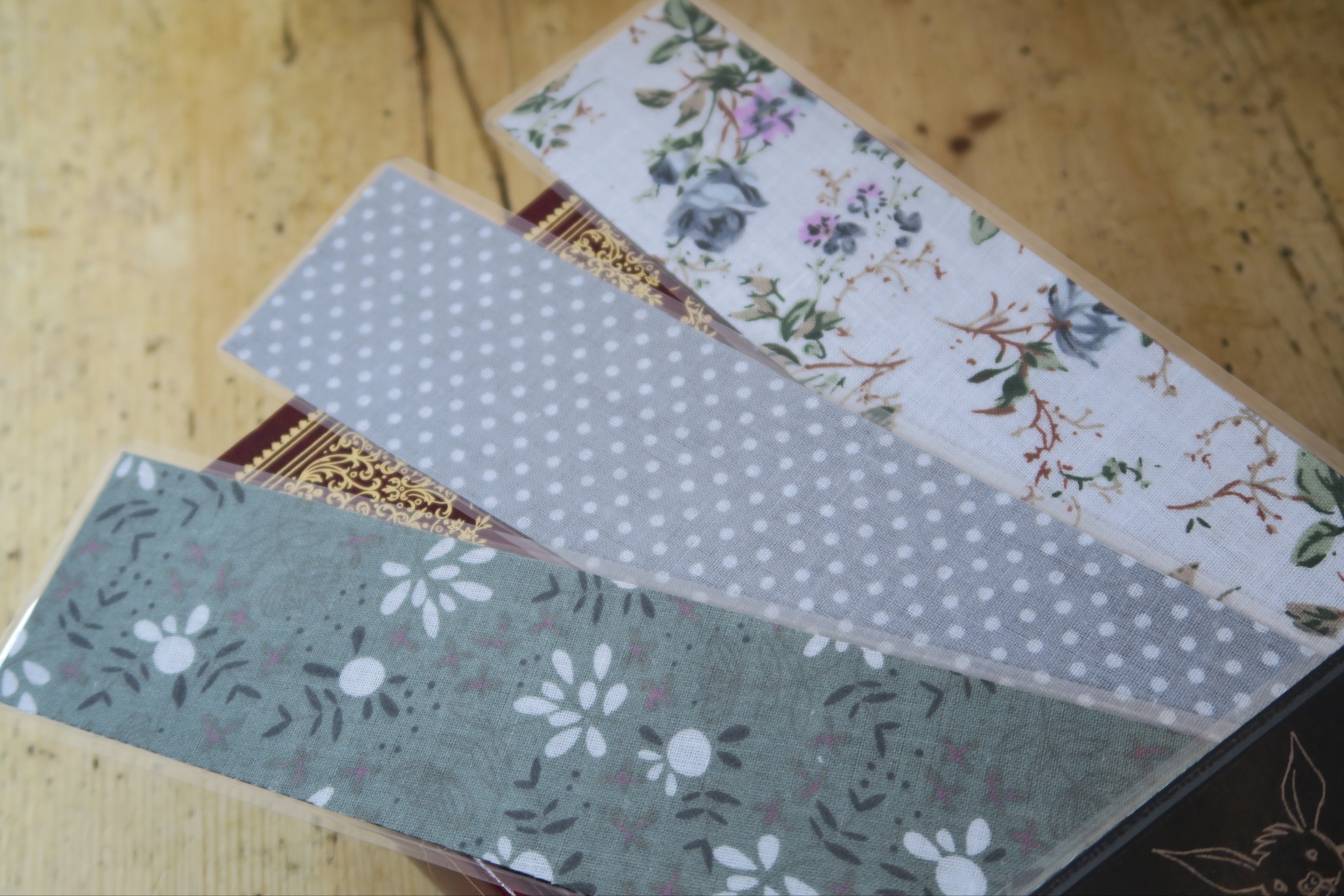 Closer view of the three fabric backing otptions, from bottom left to top right: Green Floral, Grey Dotted, White Floral.