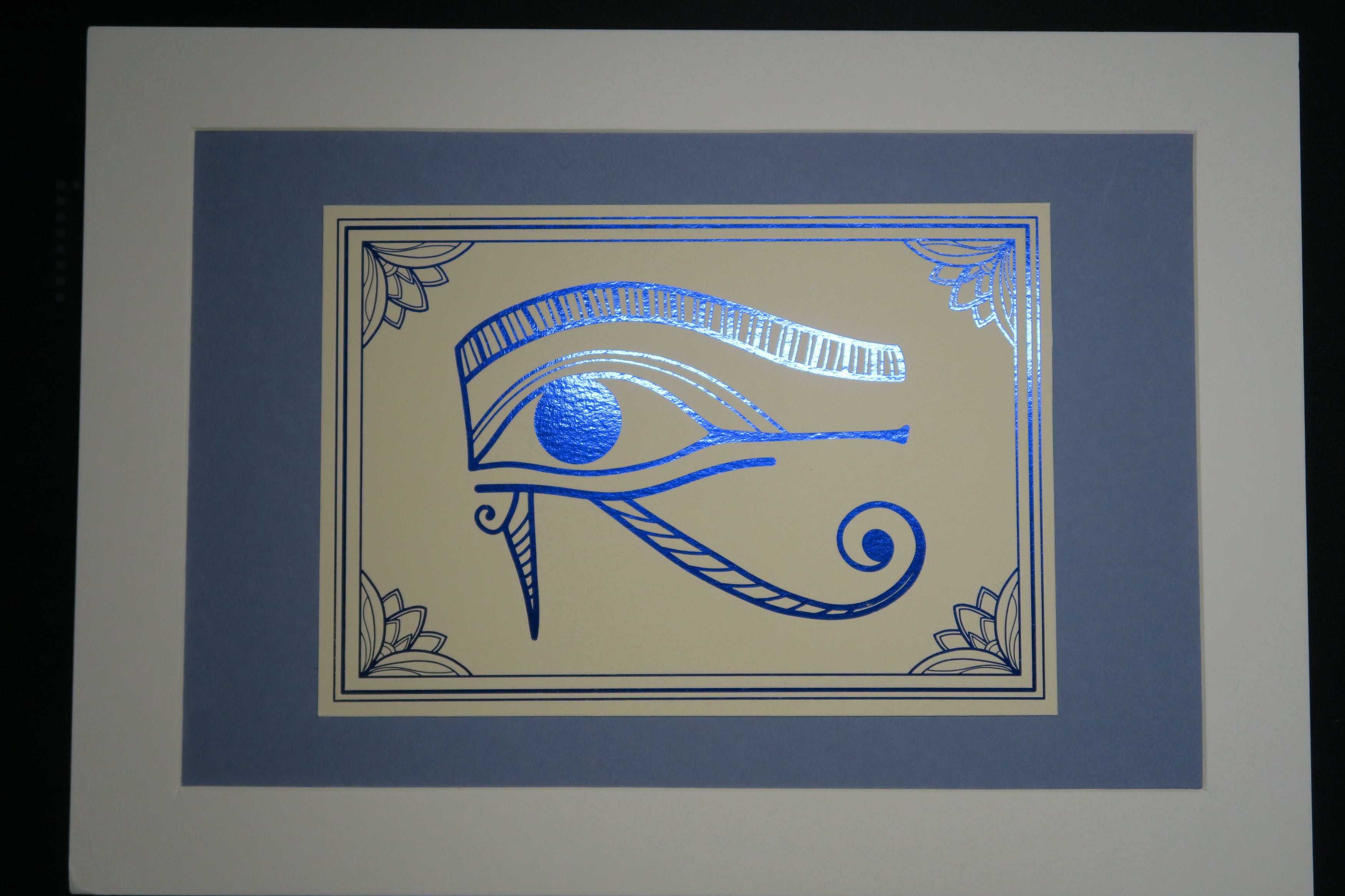 The blue foiled Eye of Horus print mounted on medium grey backing.