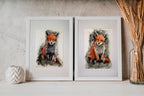 Two framed artworks of foxes on a neutral background with decorative elements. The two fox versions available. On the left is Fox Version 1, on the right is Fox Version 2 (which has slightly lighter-coloured chest fur.