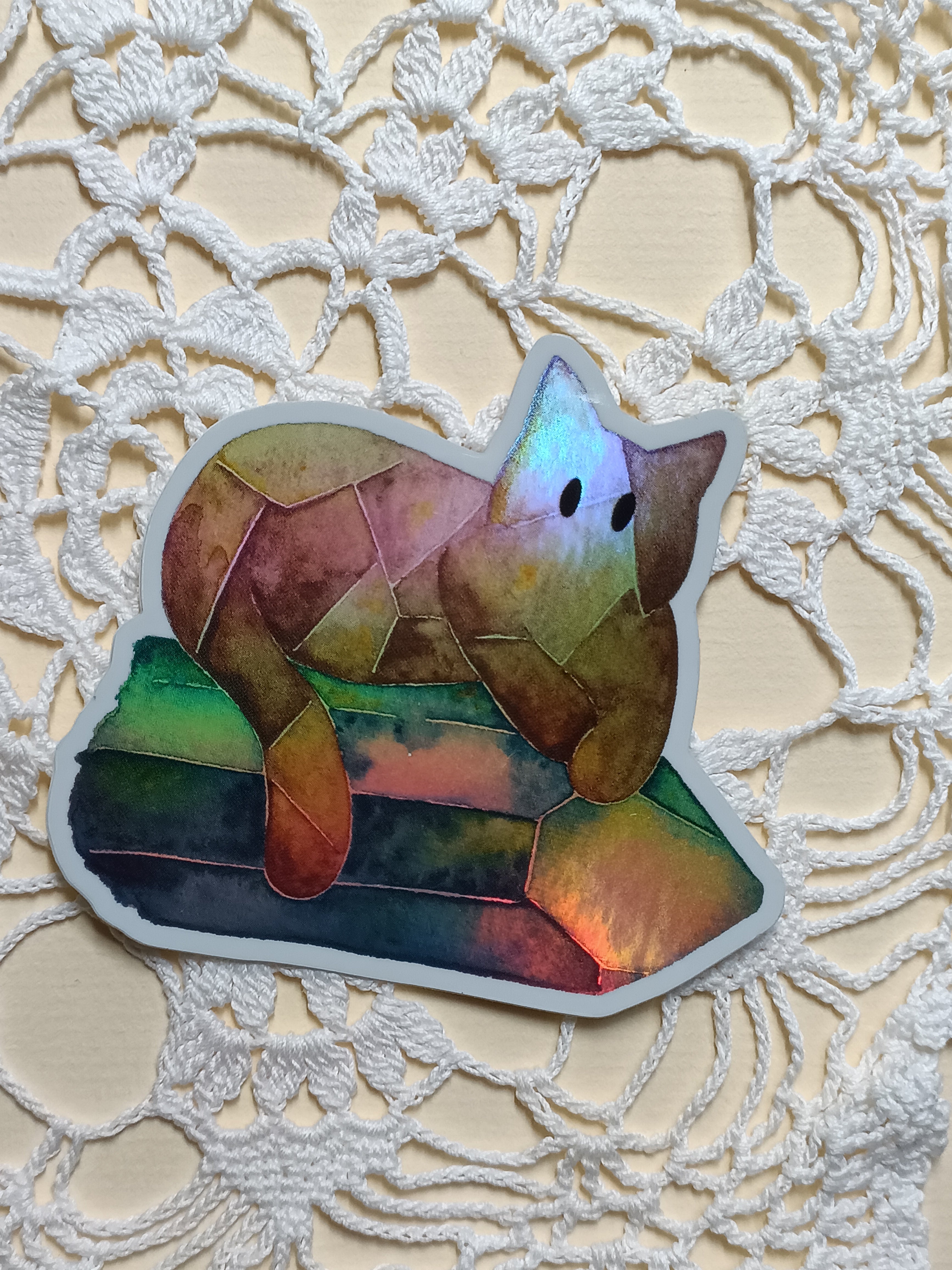 Holographic cat on a crystal sticker on a textured white background
